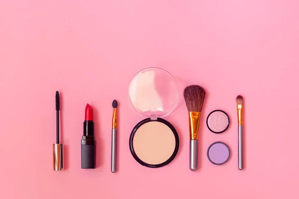 Trucchi cosmetici e pennelli come confine su sfondo rosa . — Foto Stock