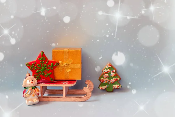 Altın hediye kutusu, zencefilli kurabiye, ahşap kızak ve mavi arka planda Noel kardan adam.. — Stok fotoğraf