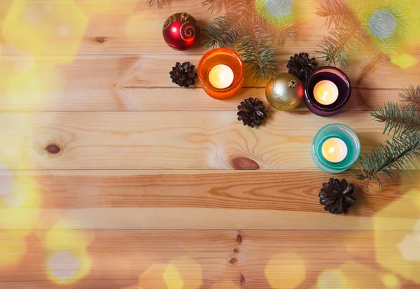 Ramas de abeto, velas en candelabros de vidrio, conos de pino y bolas de Navidad sobre fondo de madera . — Foto de Stock