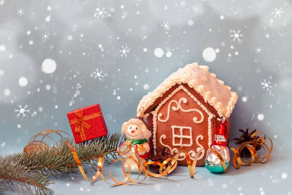 Küçük zencefilli kurabiye evi, kırmızı hediye kutusu ve mavi arka planda kardan adamlar.. — Stok fotoğraf
