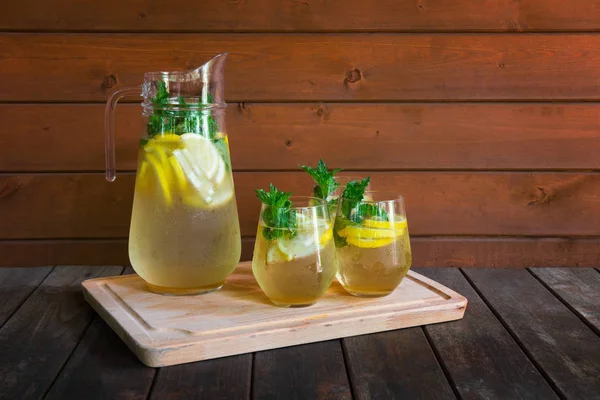 Limonada de verão fria no jarro e óculos na mesa de madeira . — Fotografia de Stock