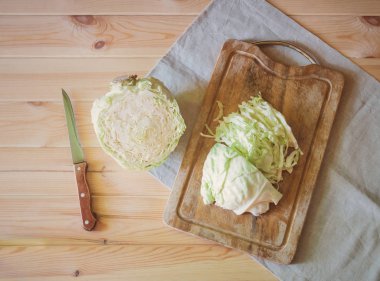 Kesme tahtasında taze kesilmiş lahana ve ahşap masada mutfak bıçağı.. 