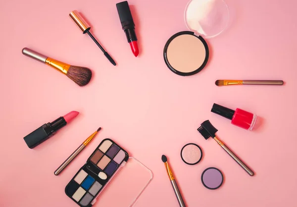 Telaio fatto di trucco cosmetici e spazzole su sfondo rosa . — Foto Stock