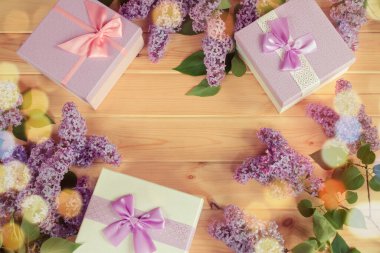 Hediye kutuları ve ahşap arka planda bir çerçeve gibi taze leylak çiçekleri.. 