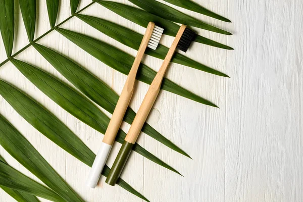 Beyaz Ahşap Arka Planda Beyaz Siyah Renkli Bambu Diş Fırçaları — Stok fotoğraf