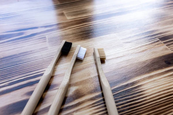 Três Escovas Dentes Bambu Multicoloridas Repousam Sobre Fundo Madeira Amigo — Fotografia de Stock