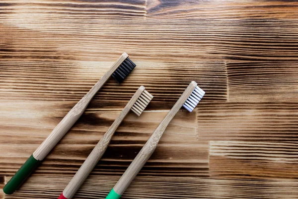 Three Multi Colored Bamboo Toothbrushes Lie Wooden Background Eco Friendly — Stock Photo, Image