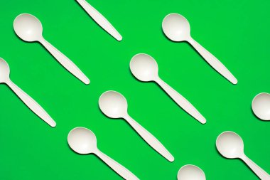 Yeşil arka planda tek kullanımlık mısır nişastası. Biyo-çözünebilir sofra takımı. Çevre dostu. İzole et kromakey. Plastik değiştirme. modern biyomateryaller