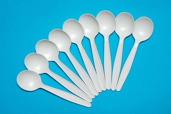 biodegradable disposable tableware. spoons from corn starch. eco friendly. blue background. isolate. bioplastics