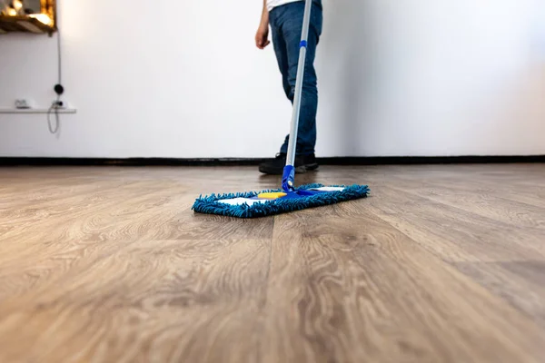 Bir adamın ellerinde yakın plan paspas. Dairede ve ofiste genel temizlik.