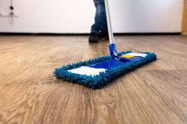 Bir adamın ellerinde yakın plan paspas. Dairede ve ofiste genel temizlik.