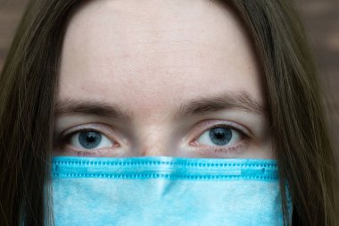 Tıbbi maskeli kadın portresi. Soğuk bir bakış. Coronavirus. Virüs enfeksiyonu. Grip. Salgın. Covid-19. yakın plan