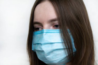 Beyaz arka planda tıbbi maskeli kadın portresi. Soğuk bir bakış. Coronavirus. Virüs enfeksiyonu. Grip. Salgın. covid-19