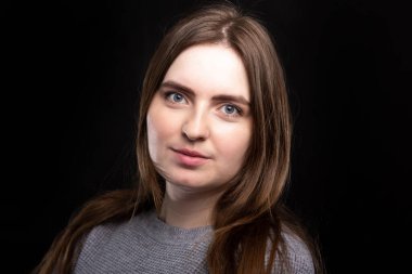 Siyah arka planda uzun sarı saçlı genç bir kızın portresi. Yakın plan. İzole et. Avrupa görünüşü. Gülümseyen bir kadın