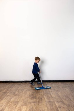 Küçük bir çocuk, ailesinin daireyi paspaslamasına yardım ediyor. Evin genel temizliği.