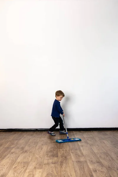 a little boy helps parents mop the floor in the apartment. general cleaning of the house.