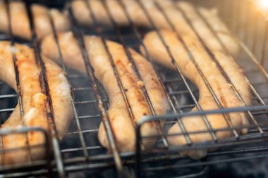 Sosisler ızgarada yatıyor ve kazıkta kızartılıyor. doğada piknik. parlak renklendirme.