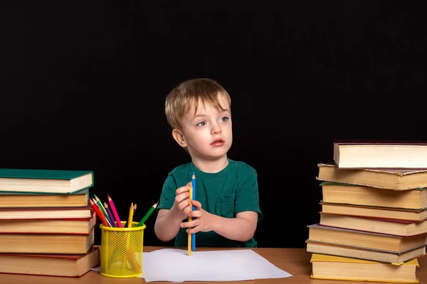 Niño Pequeño Dibuja Con Lápiz Escritorio Junto Dos Pilas Libros —  Fotos de Stock