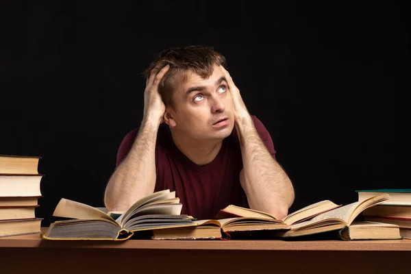 Joven Estudiante Sentado Una Mesa Con Libros Con Una Mirada —  Fotos de Stock