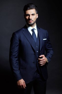 Stüdyoda mavi elbiseli şık bir adam.