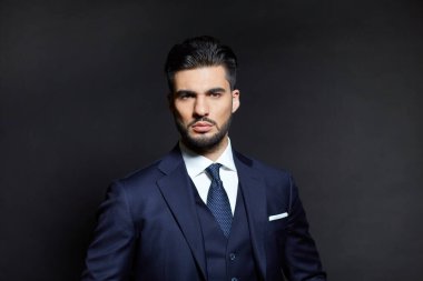 Stüdyoda mavi elbiseli şık bir adam.