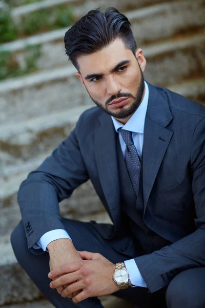 Moda işadamı eski merdivenlere oturur.