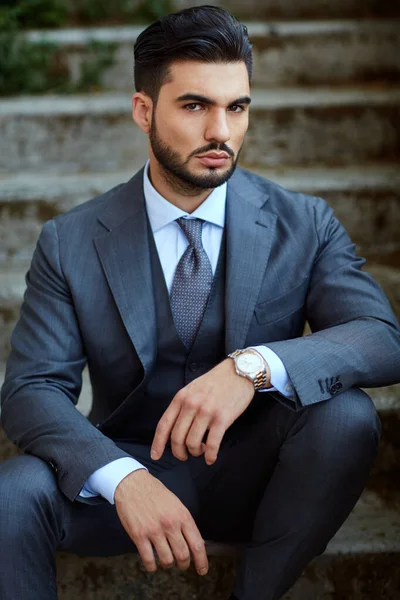 Moda işadamı eski merdivenlere oturur.