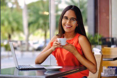 Latin Amerikalı kız bir kafede kahve molası verdi.