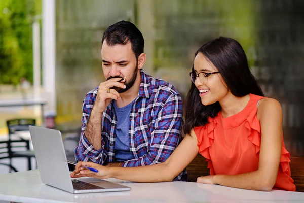 Laptop ve kafede erkek öğrencilere ders veriyor.