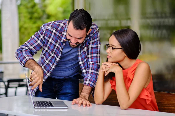 Laptop ve kafede erkek öğrencilere ders veriyor.