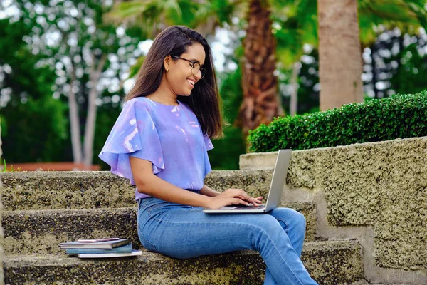 Sınavlara bilgisayarla hazırlanan gülümseyen öğrenci kız.