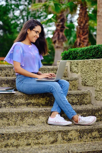 Smiling student girl preparing for exams outdoors with computer — Stock Photo, Image