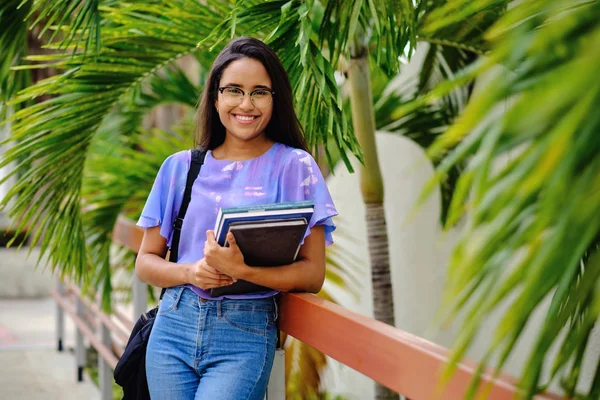 Üniversite kampüsü bahçesinde cep telefonuyla konuşan öğrenci kız.