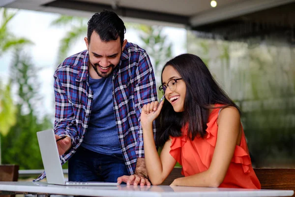 Laptop ve kafede erkek öğrencilere ders veriyor.