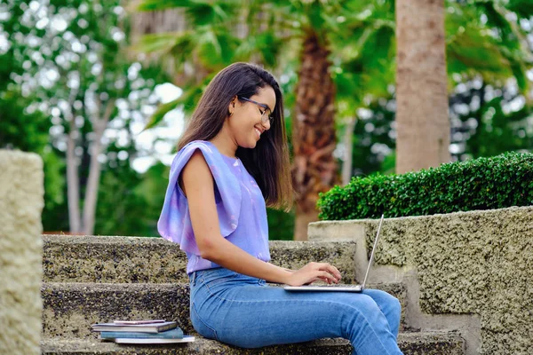 Smiling student girl preparing for exams outdoors with computer — Stock Photo, Image