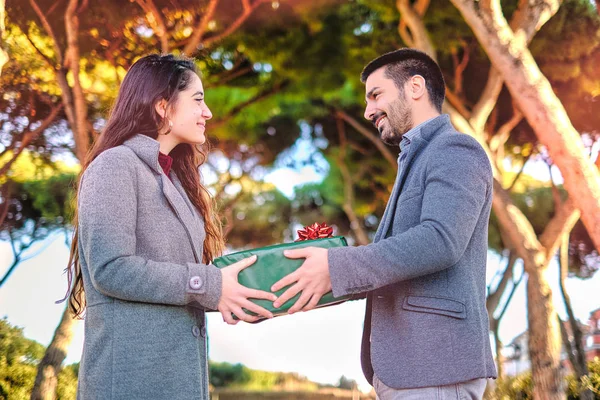 Young couple in love having fun at the park and enjoy in beautiful nature with mediterranean trees in soft blurred background - valentine deep emotion and love feelings concept - warm color image Stock Image