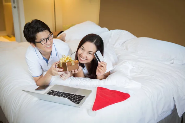 Asiatisk familj använda dator notebook för Chirstmas shopping på säng — Stockfoto