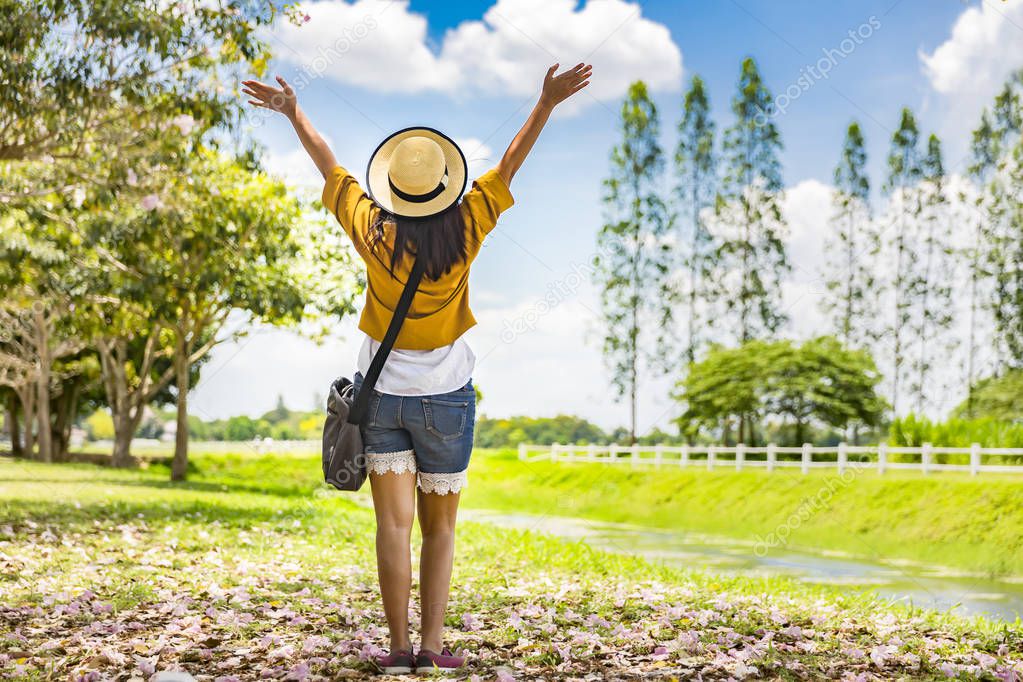 Asian traveller woman relax in green field park with blue sky, Concept of freedom life or travel