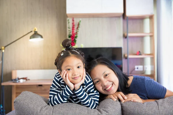 Asiatiska mor och dotter avkopplande på soffan i vardagsrummet — Stockfoto