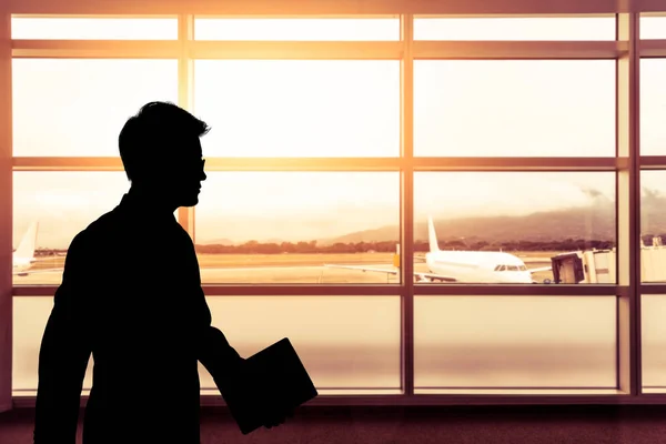 Homem de negócios silhueta andando no aeroporto com luz solar fulgurante e — Fotografia de Stock