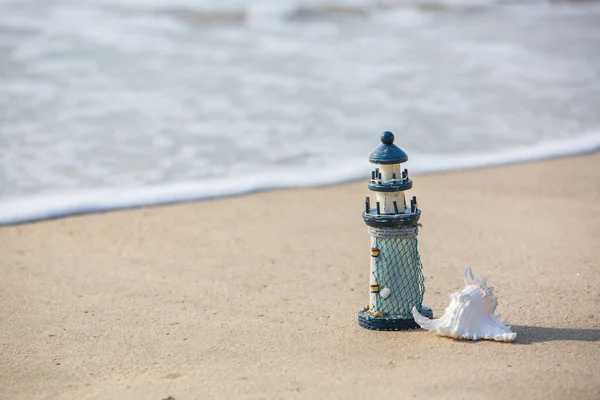 Fyren leksak på stranden med havet våg, begreppet avkoppling — Stockfoto