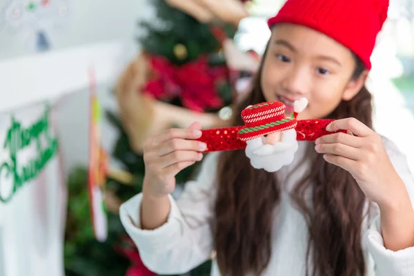 Bezaubernde asiatische Mädchen mit Weihnachtsmann Spielzeug glücklich lächelnd zu Hause mit ch — Stockfoto