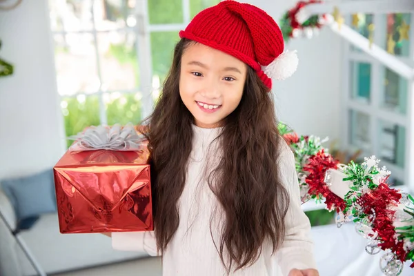 Bedårande asiatisk flicka hålla röd presentförpackning glad leende hemma med — Stockfoto
