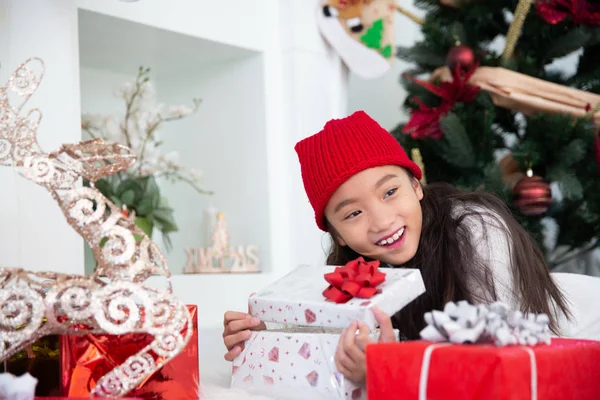 Маленькая азиатка, нюхающая открытую подарочную коробку, празднует Рождество , — стоковое фото