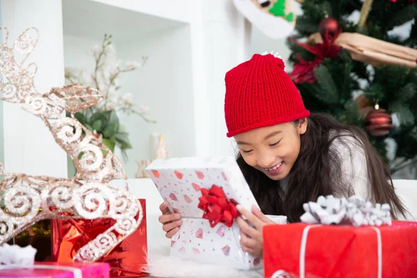 Pequeña chica asiática riendo abierta caja de regalo celebrar la víspera de Navidad — Foto de Stock