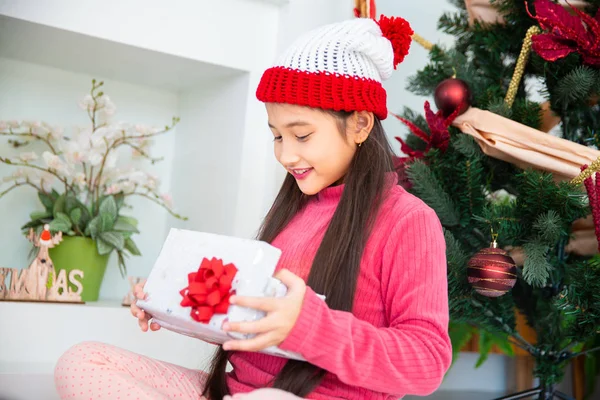 Liten asiatisk flicka lukta öppna presentförpackning fira julafton, — Stockfoto