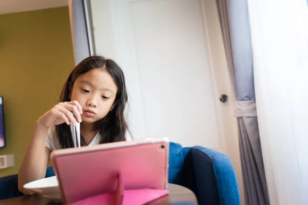 Klein Aziatisch meisje kijken naar internet content in computer tablet d — Stockfoto