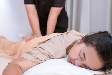 Kadın, Tayland geleneksel vücut masajı terapistiyle rahatlıyor.