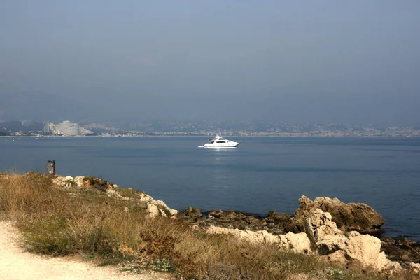 Antibes France 13. Oct 2008.  Villeneuve-Loubet - The remote side of the Marina Baie des Anges viewed from Antibes. Wave shaped buildings. White ship.