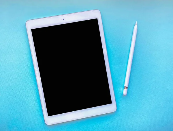 Tablet mock up on table with stylus isolated on blue background. Business concept.
